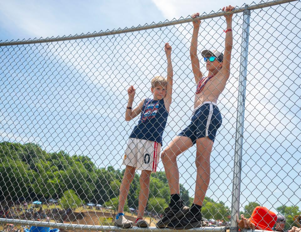 Fans climb the fences for a better angle during the KTM RedBud National Lucas Oil Pro Motocross Championship Saturday, July 2, 2022 at the RedBud MX track in Buchanan, Mich.