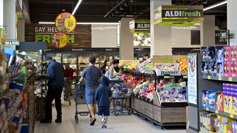 shoppers push trolley Aldi aisle