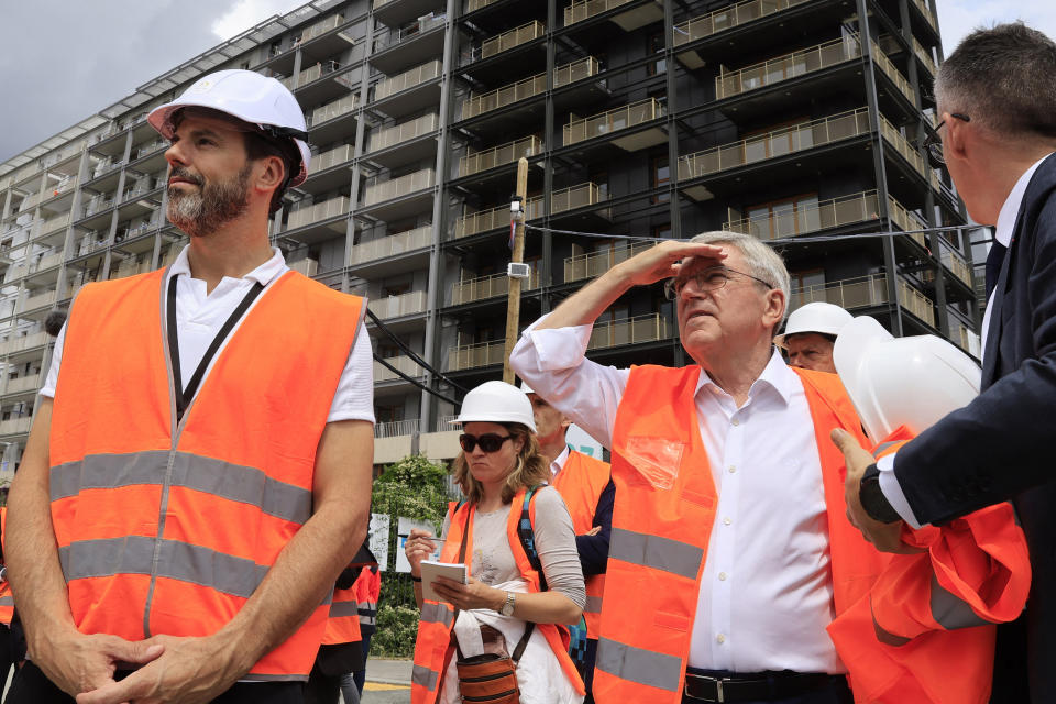 International Olympic Committee (IOC) president Thomas Bach, second left, visits the Athletes' village in Saint-Ouen-sur-Seine, outside Paris, Tuesday, July 25, 2023. (Pascal Rossignol/Pool via AP)