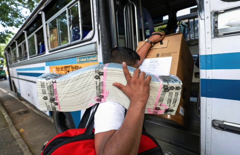 An election official carries ballot papers into a bus from a distribution center to polling stations, ahead of country's presidential election scheduled on November 16, in Colombo