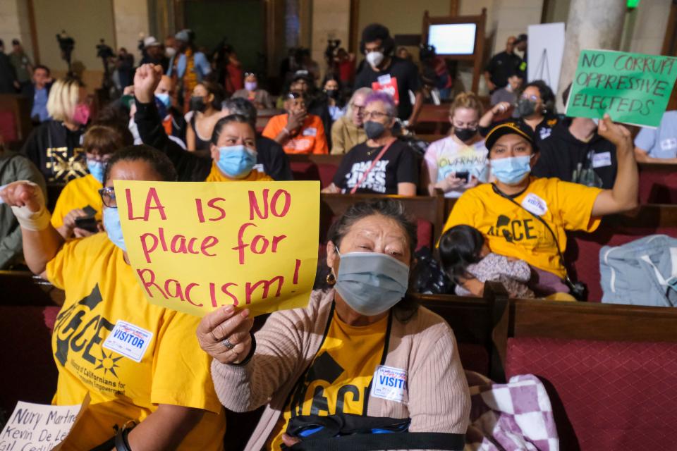 People hold signs and shout slogans before the start of the Los Angeles City Council meeting Oct. 11, 2022 in Los Angeles.