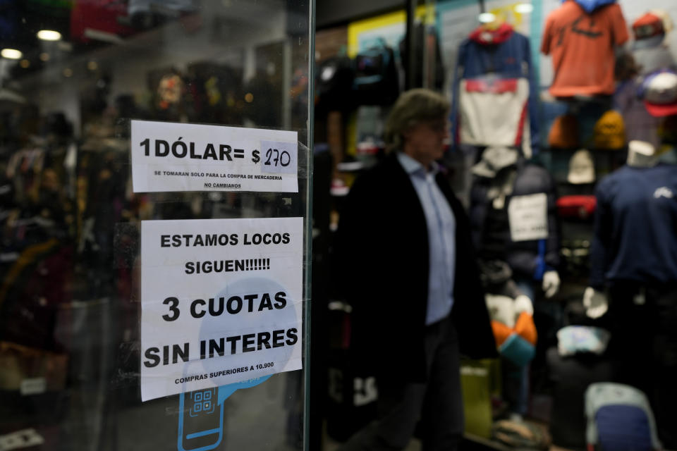 Una tienda de ropa anuncia el tipo de cambio informal de dólares estadounidenses con el peso argentino que utiliza para los turistas que pagan en moneda extranjera en Buenos Aires, Argentina, el jueves 14 de julio de 2022. (AP Foto/Natacha Pisarenko)