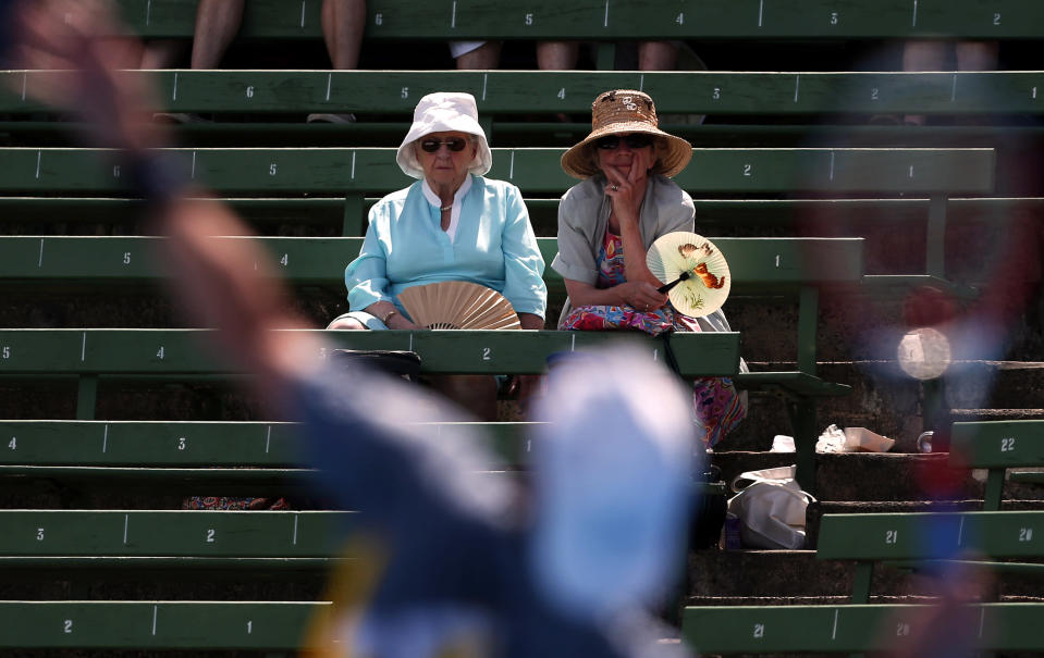 Two ladies with fans watch France's Paul-Henri Mathieu serve during his match against Italy's Simone Bolelli at the Kooyong Classic tennis tournament in Melbourne January 10, 2013. REUTERS/David Gray (AUSTRALIA - Tags: SPORT TENNIS TPX IMAGES OF THE DAY)