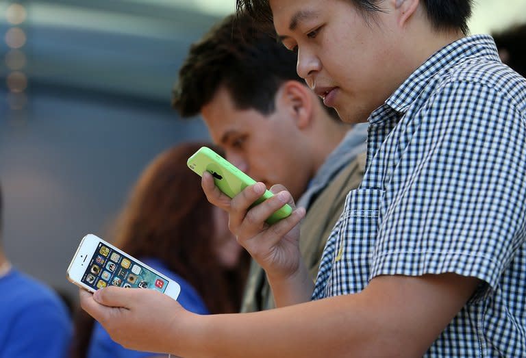 An Apple Store customer looks at the new iPhone 5C and 5S in Palo Alto on September 20, 2013. Apple said it sold a record nine million iPhones in the three days after launching two new versions of the smartphone