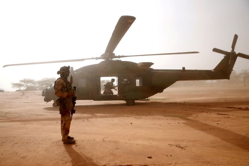 FILE PHOTO: FILE PHOTO: A French soldier stands guards in front of an NH90 Caiman military helicopter during Operation Barkhane in Ndaki
