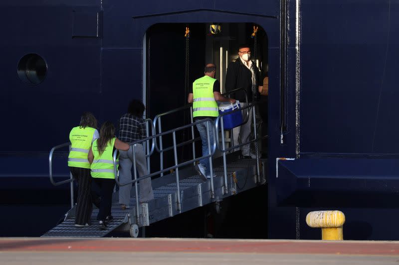 Health Ministry officials enter the Mein Schiff 6 cruise ship moored at the dock of Piraeus after some of the crew members tested positive for the coronavirus disease (COVID-19), in Piraeus