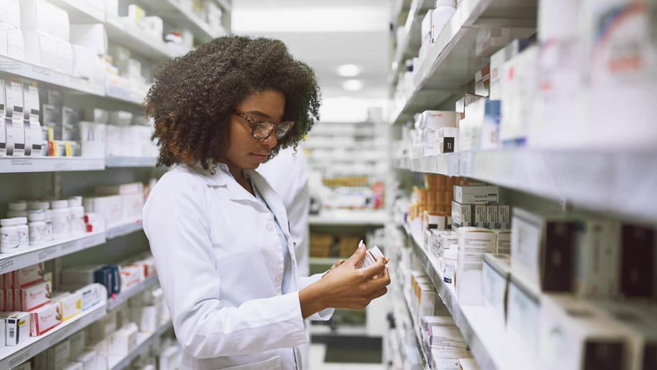 Shot of a focused young female pharmacist walking around and doing stock inside of a pharmacy.