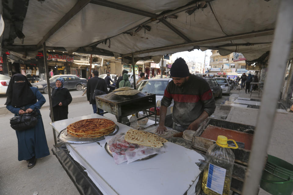 Man bakes bread in the city of Idlib, Syria, Monday, March 9, 2020 during the truce, brokered by Turkey and Russia, which halted a terrifying three-month air and ground campaign that killed hundreds and sent 1 million people fleeing toward the Turkish border. (AP Photo/Ghaith Alsayed)