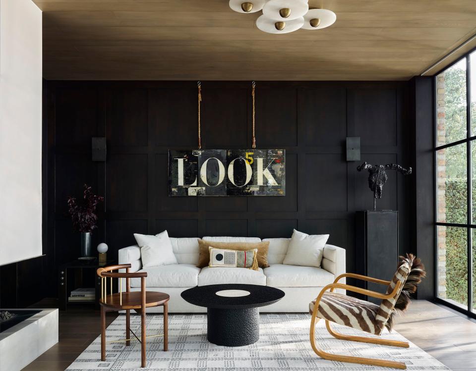 In this second-floor office, an artwork by Greg Miller dominates. A steel coffee table with travertine insert from Fair Design matches the ebonized oak paneling on the wall. The zebra-hide chair is a vintage piece by Alvar Aalto.