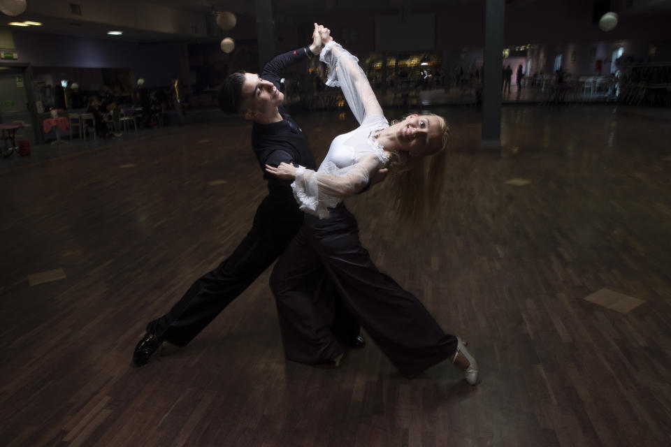 Simone Angelino, 22, left, and Florina Roxana Salcu, 21, pose for a portrait after a practice at the New Dancing Days School, in Rome, Sunday March 28, 2021. While much of Italy is in coronavirus lockdown, with live music and theatrical performances barred, cinemas shuttered and many sporting activities limited, competitive ballroom dancing is alive and well here, albeit with precautions. (AP Photo/Alessandra Tarantino)