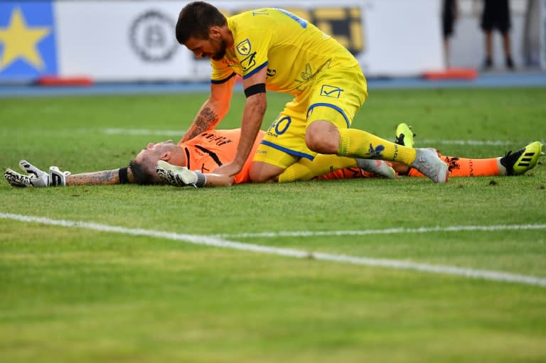 Chievo's Serbian defender Nenad Tomovic tends to goalkeeper Stefano Sorrentino after he was injured