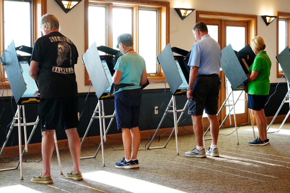 Voters cast their vote on Issue 1 at the VOA Reagan Lodge polling location in West Chester on Tuesday.