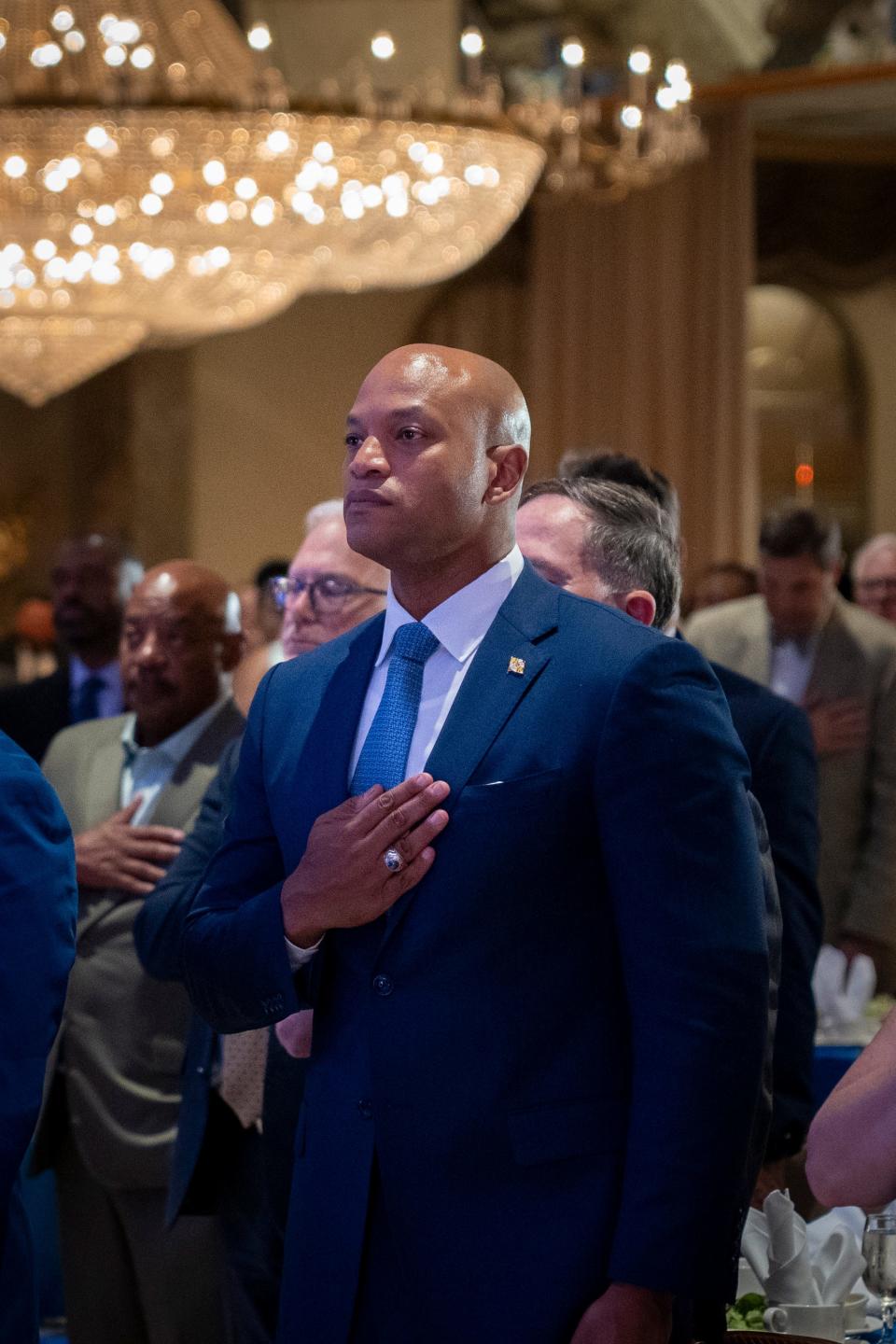 In this file photo, Maryland Governor Wes Moore (right) stands for the national anthem at the Maryland Democratic Party Gala 2024 fundraiser at Martin’s Crosswinds in Greenbelt, Md., on Thursday, June 20, 2024.