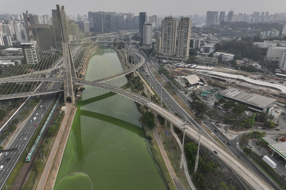 The Pinheiros River is green in Sao Paulo, Brazil, Tuesday, Sept. 10, 2024. The state's environmental authority attributes the river's new green hue to an algae bloom, the result of severe drought that has significantly lowered water levels. (AP Photo/Andre Penner)