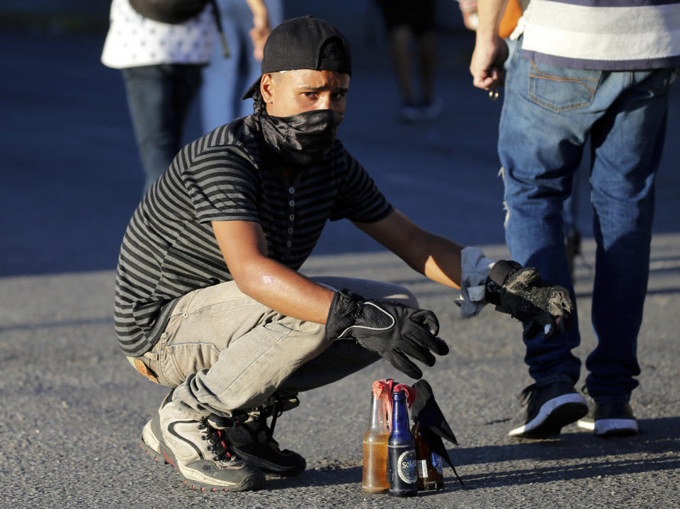 An anti-government protester readies gasoline bombs during clashes against the Venezuelan Bolivarian National Guard, after a rally demanding the resignation of President Nicolas Maduro in Caracas, Venezuela, Wednesday, Jan. 23, 2019. The head of Venezuela's opposition-run congress declared himself interim president at the rally, until new elections can be called.(AP Photo/Fernando Llano)