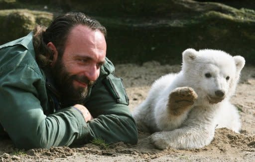 Knut, a three-month-old polar bear cub, appears to wave as he plays with his minder Thomas Doerflein during his first outing at Berlin's Zoologischer Garten zoo in 2007. Doerflein, his keeper, died at 44 of a heart attack in 2008