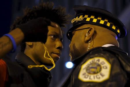 Protesters including Lamon Reccord, 16, confront police during a demonstration in response to the fatal shooting of Laquan McDonald in Chicago, Illinois November 25, 2015. Laquan McDonald, 17, was fatally shot by Jason Van Dyke, a Chicago police officer, in October 2014. REUTERS/Andrew Nelles