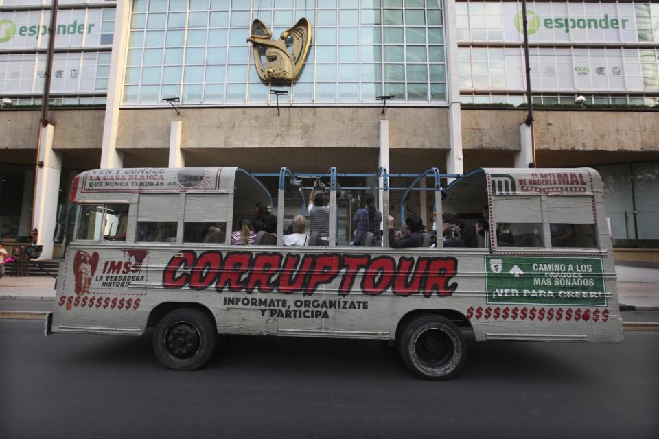 El autobús del Corruptour pasa por las calles de la Ciudad de México el domingo 5 de febrero de 2017. Se trata de la más reciente adición a los recorridos en autobuses turísticos que pasean por la Ciudad de México: El Corruptour, que en vez de llevar a sus usuarios a plazas históricas e iglesias, coloca una luz poco halagadora al turbio mundo de los chanchullos mexicanos. También invita a los peatones y a los choferes que los ven pasar a gritar “¡No más corrupción!”. (Foto AP/Marco Ugarte)