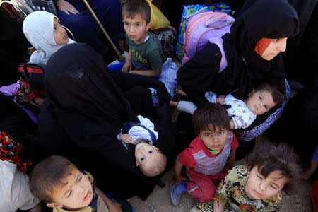 Displaced Iraqi people gather to be transported to a camp for displaced people during the battle between Iraqi forces and Islamic State militants in western Mosul, Iraq, May 17, 2017. REUTERS/ Alaa Al-Marjani