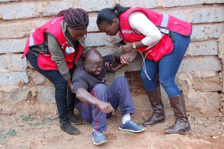 Members of the Kenya Red Cross Society attempt to evacuate an injured man during unrest in the post-election emergency response in Mathare 4A Nairobi, Kenya, August 12, 2017. Picture taken August 12, 2017. Kenya Red Cross Society/Handout via Reuters
