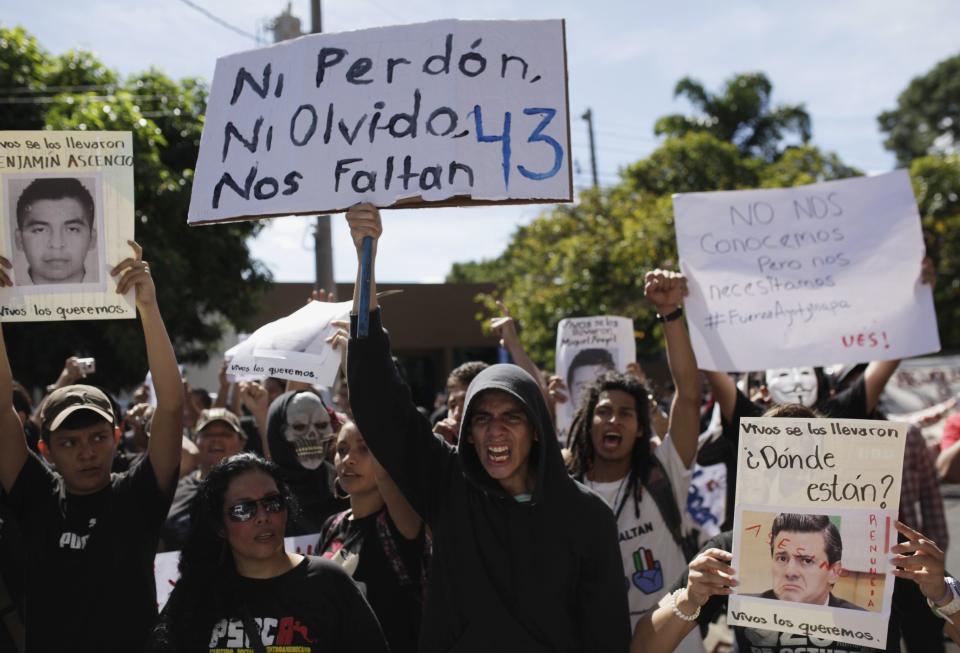 Demonstrators yell slogans in support of the missing Ayotzinapa students during a protest outside the Mexican embassy in San Salvador