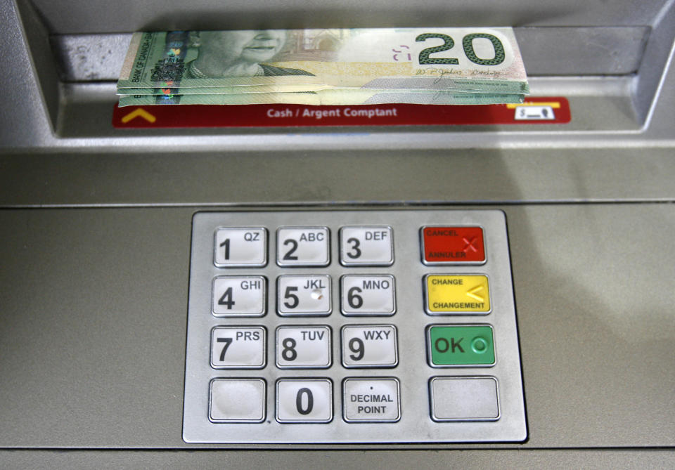 A bank machine dispenses cash in Toronto (Reuters)