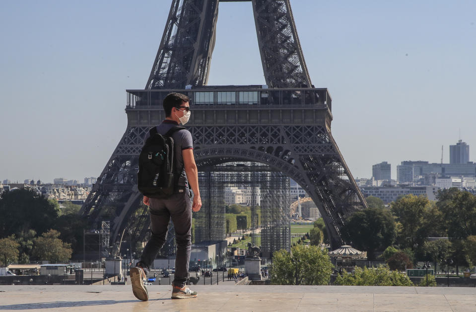 A man wearing protective a face mask as precaution against the conoravirus walk at Trocadero plaza near Eiffel Tower in Paris, Monday, Sept. 14, 2020. France sees a substantial increase of Covid-19 cases. (AP Photo/Michel Euler)