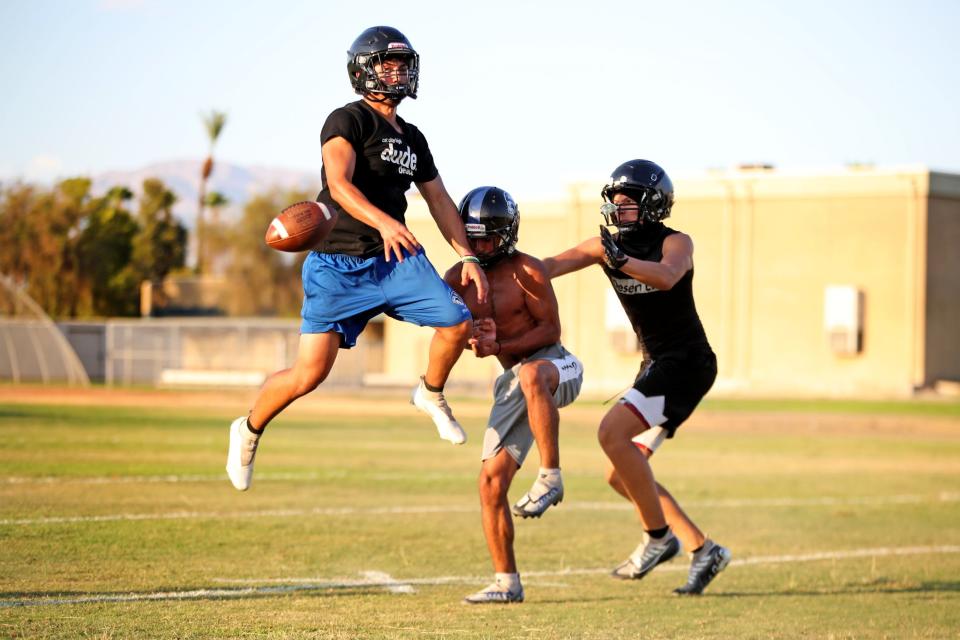 Rene Romero, left, blocks a pass during football practice at Cathedral City High School in Cathedral City, Calif., on July 27, 2023. (Syndication: Desert Sun)