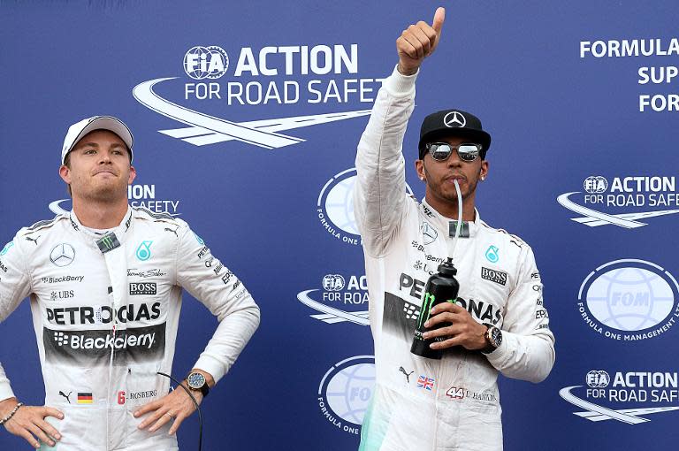 Mercedes' British driver Lewis Hamilton (R) gives the thumbs up as he celebrates taking pole next to German driver Nico Rosberg after qualifying at the Monaco street circuit in Monte Carlo on May 23, 2015