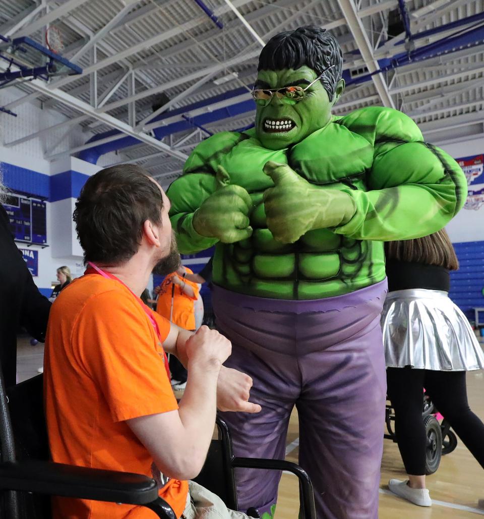 A Ravenna student dressed as the Incredible Hulk greets guests during the "Out of This World" dance party Friday, May 10, 2024, at Ravenna High School.