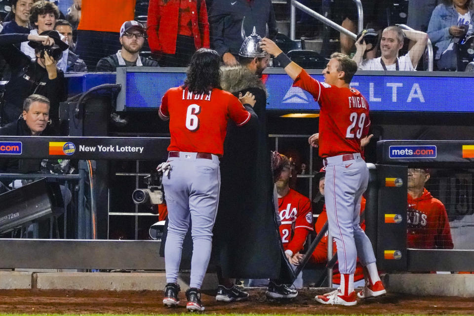 Cincinnati Reds teammates Jonathan India (6) and TJ Friedl (29) dress Christian Encarnacion-Strand, center, in a Viking costume after his home run in the fourth inning of a baseball game against the New York Mets, Saturday, Sept. 16, 2023, in New York. (AP Photo/Bebeto Matthews)