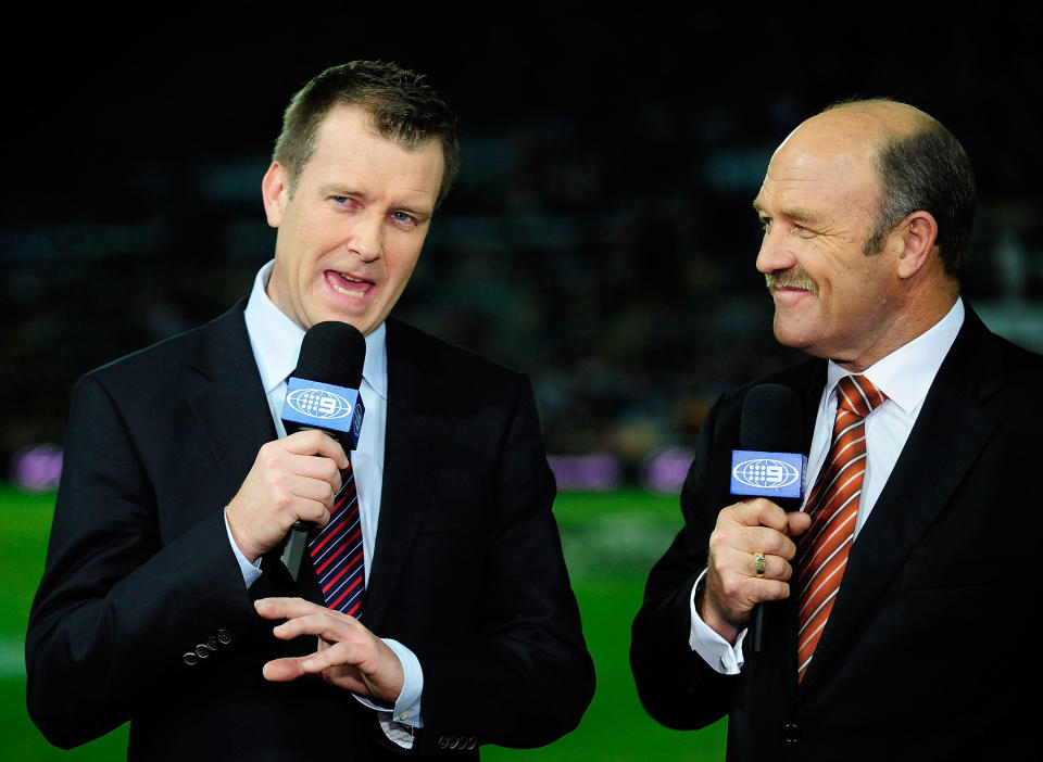 TOWNSVILLE, AUSTRALIA - AUGUST 12:  Channel 9 commentators Wally Lewis (r)and Andrew Voss do a piece to camera before the start of  the round 23 NRL match between the North Queensland Cowboys and the Brisbane Broncos at Dairy Farmers Stadium on August 12, 2011 in Townsville, Australia.  (Photo by Ian Hitchcock/Getty Images)