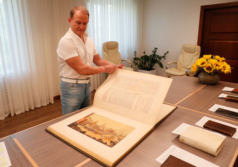 Ukrainian opposition politician Medvedchuk shows a book from his collection during an interview in Kyiv