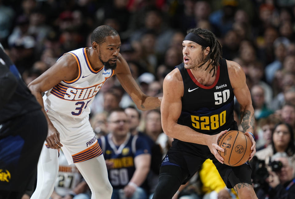 Denver Nuggets forward Aaron Gordon, right, is defended by Phoenix Suns forward Kevin Durant during the first half of an NBA basketball game Wednesday, March 27, 2024, in Denver. (AP Photo/David Zalubowski)