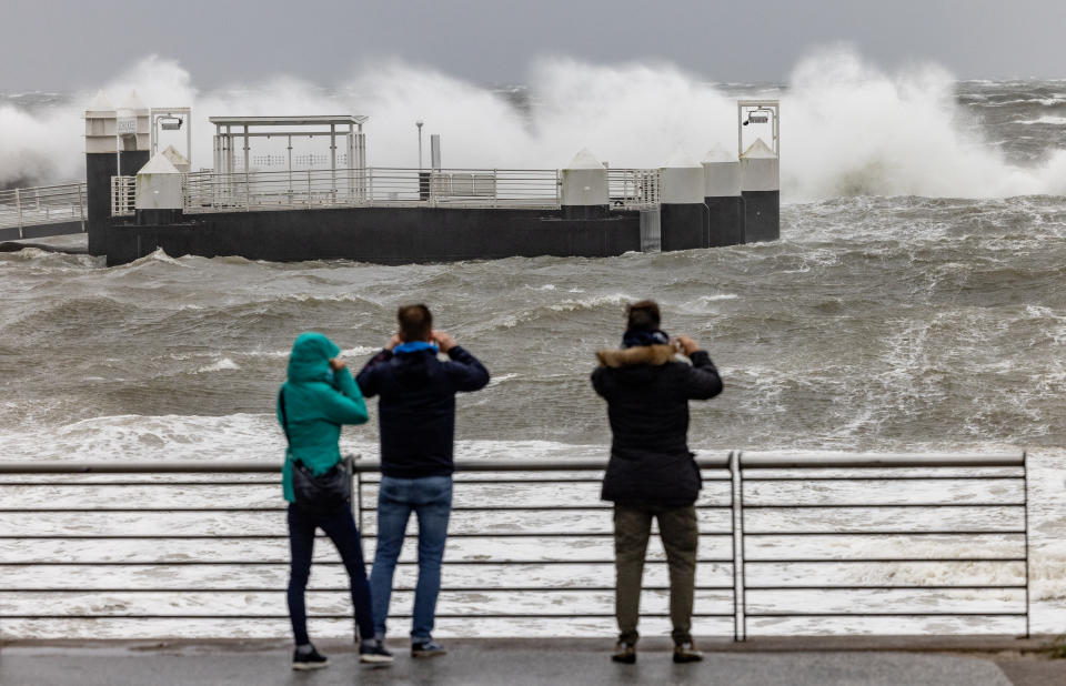 Kiel: Besucher des Hafens in Schilksee fotografieren die Ã¼ber die Hafenanlagen niedergehenden Wellen. In der Kieler und Lübecker Bucht wird nach der Vorhersage des Bundesamtes für Seeschifffahrt und Hydrographie (BSH) eine schwere Sturmflut erwartet (Foto: Axel Heimken/dpa)