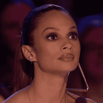 Alesha Dixon's looks left to right with her eyes wide open in shock