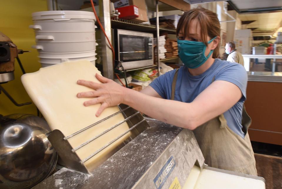 Jessica Schultz, owner of the Herb & Honey Bakery runs dough through a sheeter on May 5, 2021. Shultz operates her bakery inside Urbaniak Brothers Quality Meats in Erie.