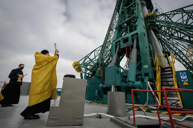 A Russian Orthodox priest blesses the Soyuz rocket at the launch pad, a traditional practice at the Baikonur Cosmodrome. / Credit: NASA