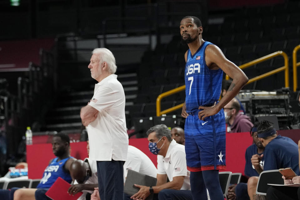 United States coach Gregg Popovich, left, and forward Kevin Durant (7) look on from the side line during their loss to France in a men's basketball preliminary round game at the 2020 Summer Olympics, Sunday, July 25, 2021, in Saitama, Japan. (AP Photo/Eric Gay)