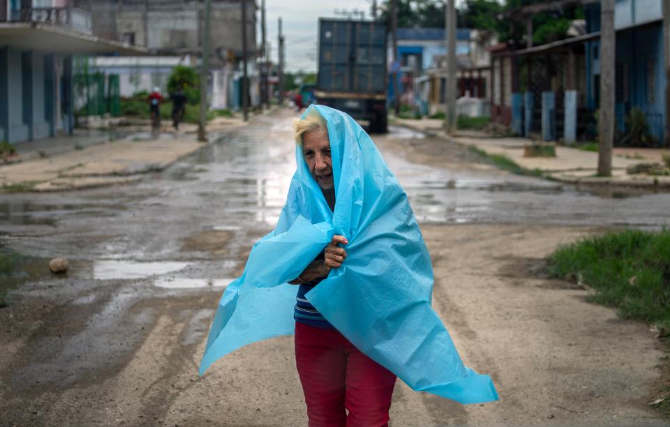 A resident uses plastic as protection from the rain in Batabano, Cuba on Monday as Hurricane Ian approaches (AP)