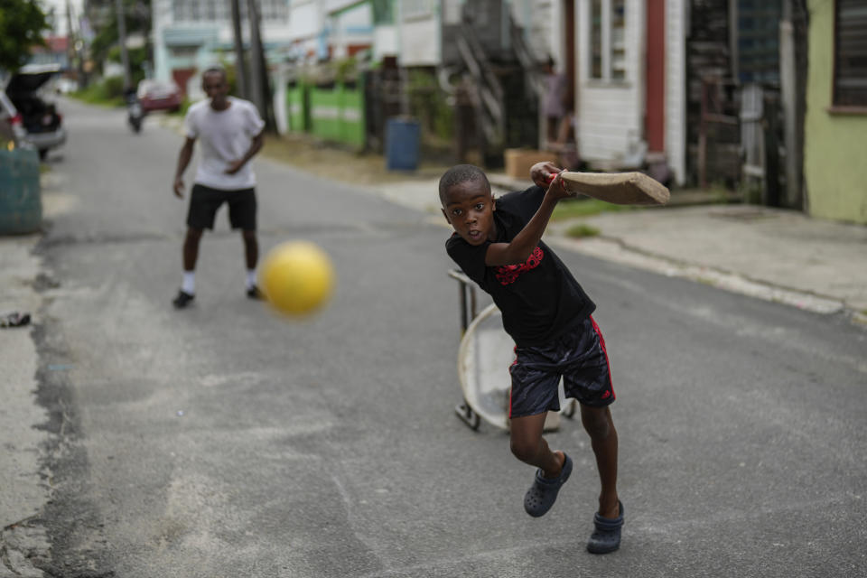 People play cricket on the street in the Charlestown neighborhood of Georgetown, Guyana, Sunday, June 2, 2024. Guyana is one of the venues for the T20 Cricket World Cup. (AP Photo/Ramon Espinosa)