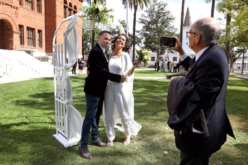 Carlos Alvarez, far right, photographs his son Enrique with his bride, Afrouz Alvarez.