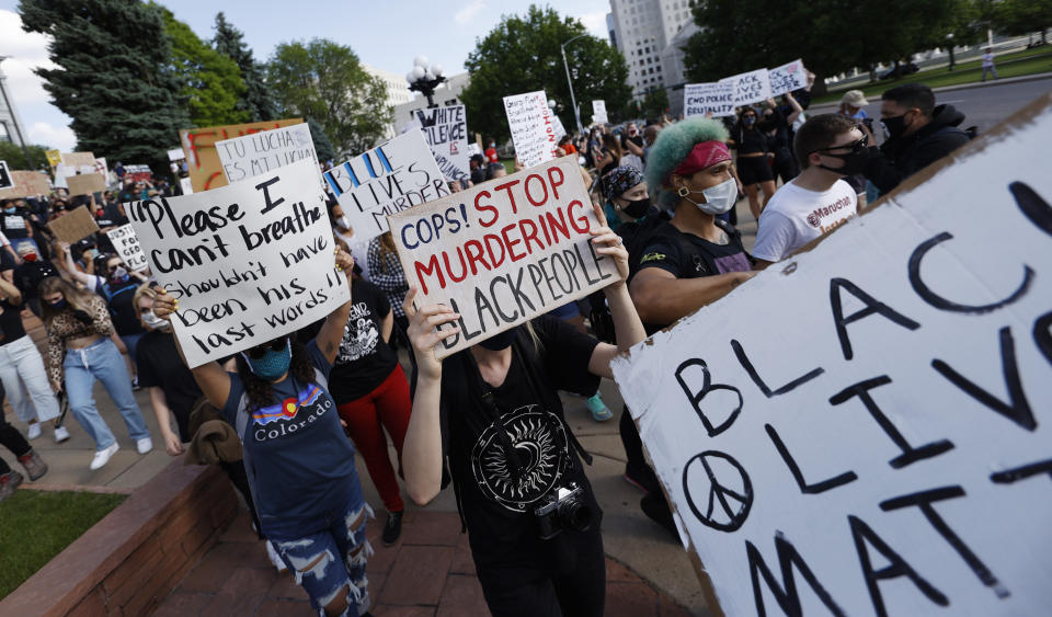 Participants carry placards as they march during a protest outside the State Capitol over the death of George Floyd, a handcuffed black man in police custody in Minneapolis, Thursday, May 28, 2020, in Denver. Close to 1,000 protesters walked from the Capitol down the 16th Street pedestrian mall during the protest. (AP Photo/David Zalubowski)