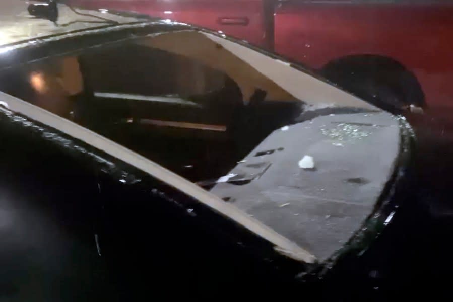 This image taken from video provided by JJ Unger, shows hail damage to a window of vehicle, Monday night, May 20, 2024, in Yuma, Colo. Residents in the small city in northeastern Colorado were cleaning up Tuesday after hail the size of baseballs and golf balls pounded the community, with heavy construction equipment and snow shovels being used to clear hail that had piled up knee-deep the night before. (JJ Unger via AP)