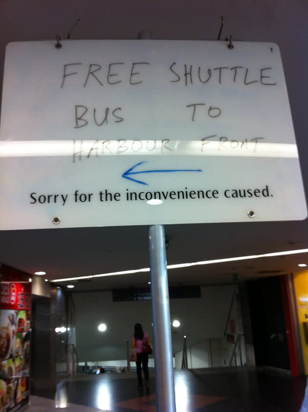 Signs directing commuters to the bus stop where shuttle bus services were offered were placed at strategic locations on the way out of Dhoby Ghaut station's North-South Line side. (Yahoo! photo/Lin Wenjian)