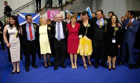 Nicola Sturgeon (C) leader of the Scottish National Party poses with candidates as she arrives at a counting centre in Glasgow, Scotland, May 8, 2015. REUTERS/Russell Cheyne