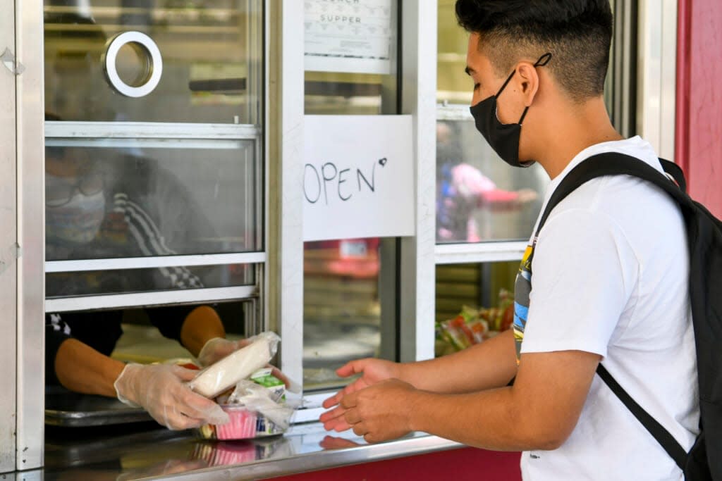 A returning student receives pre-packaged lunch at Hollywood High School on April 27, 2021 in Los Angeles, California. (Photo by Rodin Eckenroth/Getty Images)