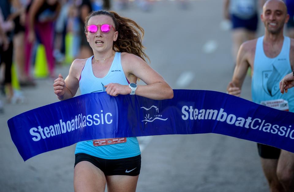 Laura Gann of Peoria breaks the tape as the top female finisher in the 2022 Steamboat Classic 15K race Saturday, June 18, 2022 in downtown Peoria. Gann finished in a time of 1:01:14.