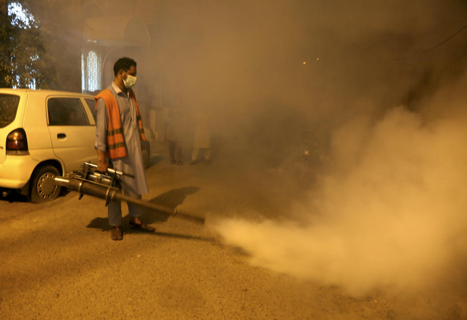 Pakistani health workers fumigate to kill mosquitos in an effort to prevent an outbreak of dengue fever, in Peshawar, Pakistan. Friday, Sept. 23, 2022. Pakistan has deployed thousands of additional doctors and paramedics in the country's worst flood-hit province to contain the spread of diseases that have killed over 300 people among the flood victims, officials said Friday. (AP Photo/Muhammad Sajjad)