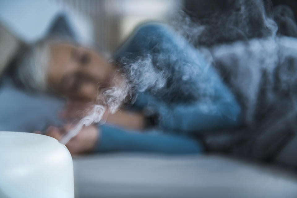 A person sleeping beside a humidifier